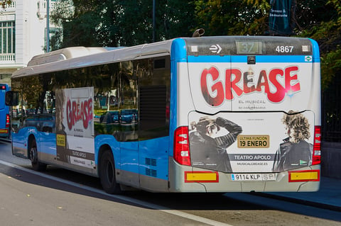 Transit bus with advertisement parked in empty lot