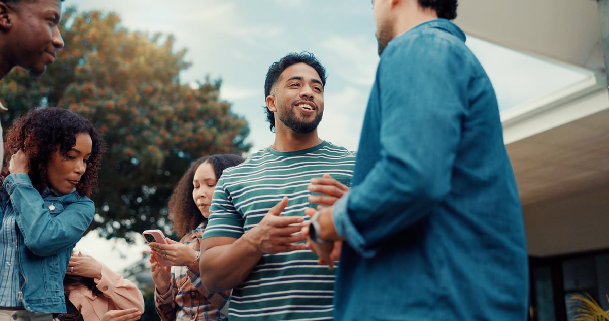 Friends, backyard and people at party for conversation, relaxing and bonding for fun on weekend. Happy, outdoor and men with women talking in garden for bbq celebration, social gathering and reunion