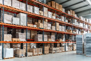 Multiple rows of tall warehouse shelving units filled with pallets for high-volume distribution