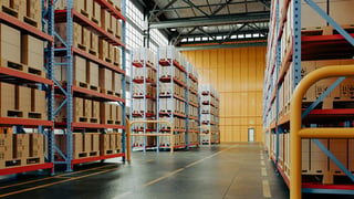 Large industrial warehouse with high shelves filled with pallets for city-wide distribution