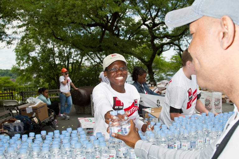 Volunteers distributing water bottles to people in need
